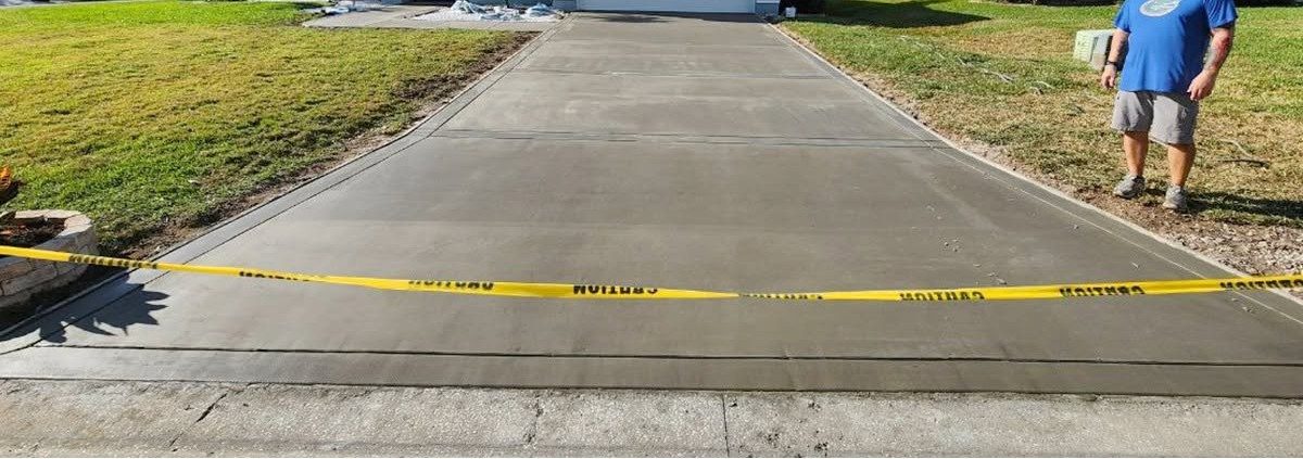 Finished concrete driveway taped off while it cures