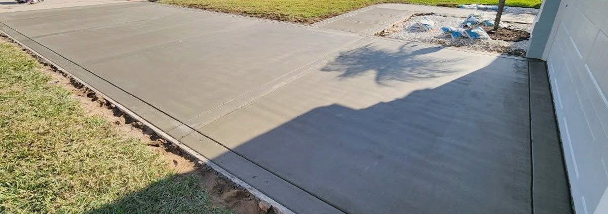 New concrete driveway poured beside a garage