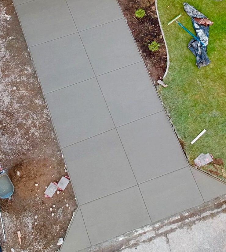 Concrete walkway poured alongside a landscaped yard